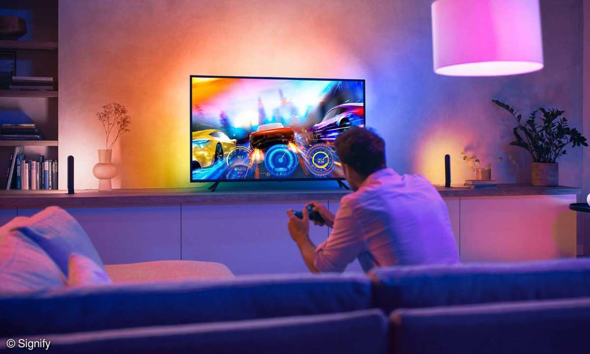 Mann spielt per Controller ein Spiel mit eingeschalteter Philips Hue Beleuchtung