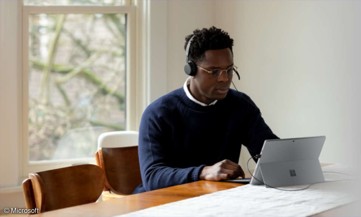 Mann nutzt das Microsoft Modern USB Headset im Homeoffice am Tablet