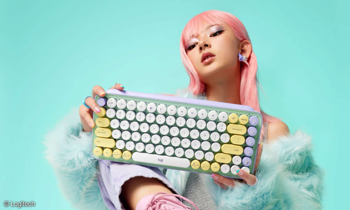 Frau in Pastellfarben hält die Logitech POP Keys