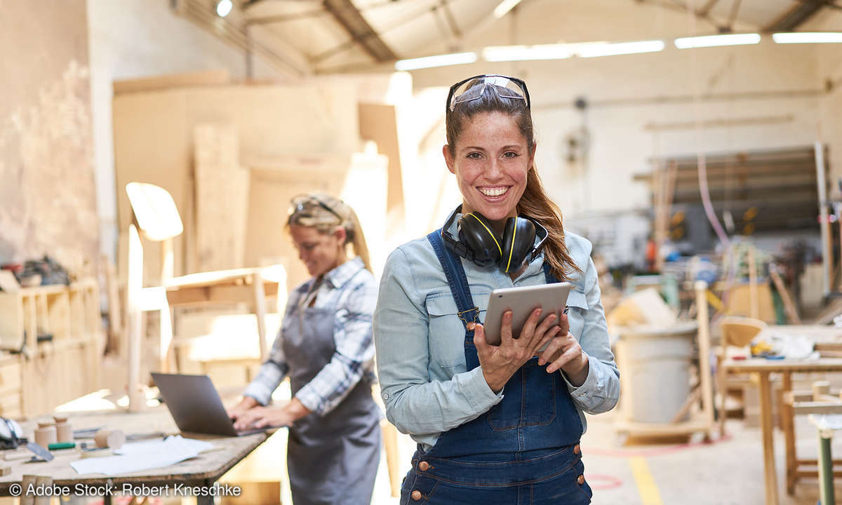 Handwerkerin mit einem Tablet in einer Werkstatt