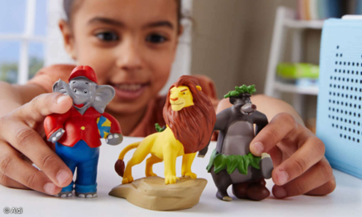Kleines Kind spielt mit drei Tonie-Figuren.