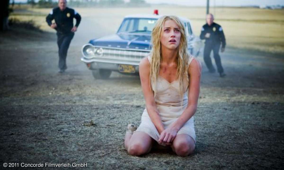 Kristen (Amber Heard) kniet am Boden, gerade hat sie ein altes Landhaus in Flammen gesetzt.